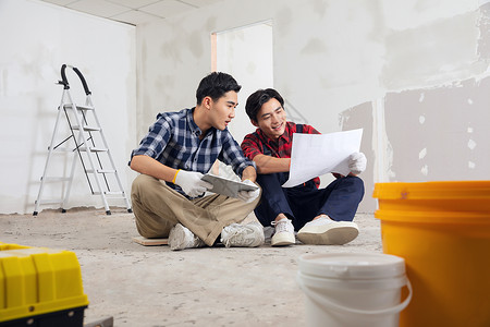 建筑平面图坐在工地上的装修工人背景