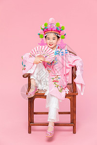 国潮儿童戏剧戏服坐着太师椅拿着折扇背景