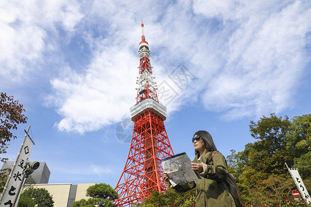 站在东京塔前看旅游地图的旅行者背景图片
