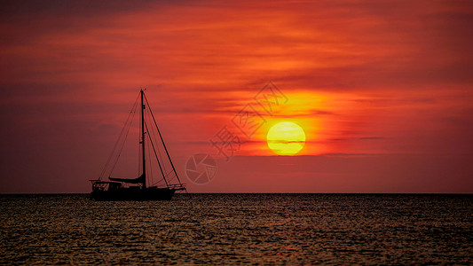 日落黄昏时海面上的帆船图片
