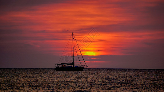 夏天结束时日落黄昏时海面上的帆船背景