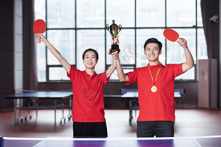 庆祝胜利的男性乒乓球运动员举奖杯庆祝的乒乓球运动员背景