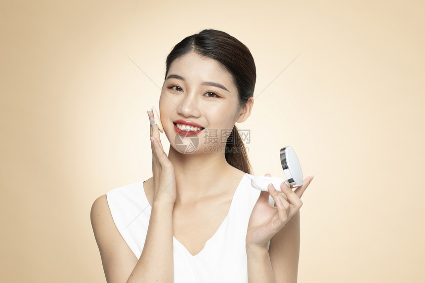 青年女性美容化妆擦粉底图片