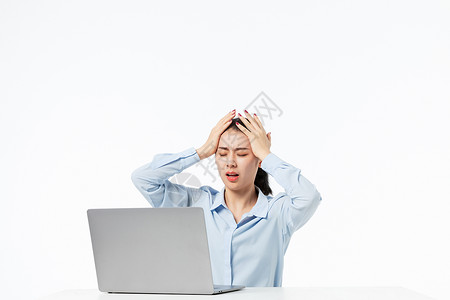 商务青年女性拿着笔记本电脑烦恼头疼图片