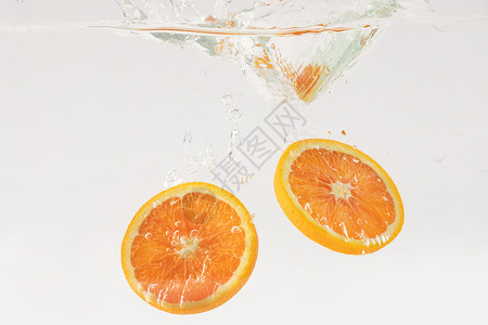 掉落水中的橙子水果切片背景