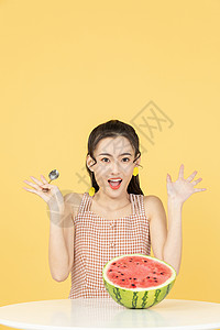 用勺子吃西瓜的甜美女性图片
