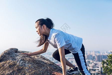 户外石头上攀岩女性高清图片