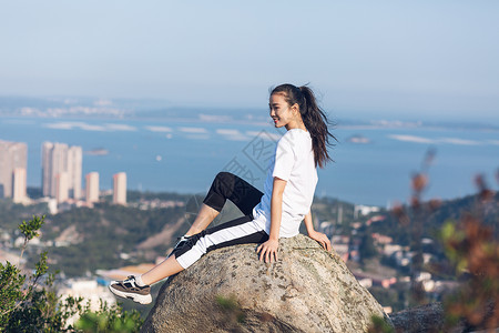 户外坐石头上面的美女背景图片