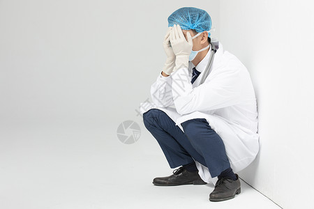 抗疫医生痛苦蹲在墙角背景图片