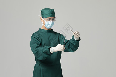 男性手术服医生拿着手术剪刀背景