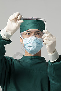 男性手术服医生拿着手术剪刀背景图片