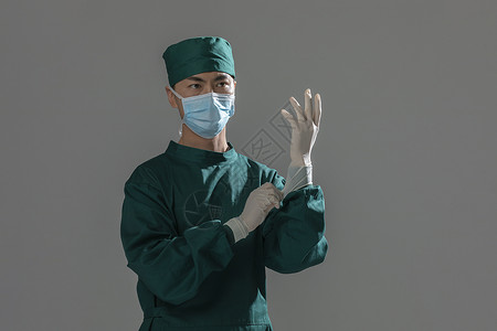 男性手术服医生戴手套背景图片