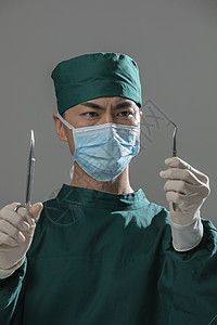 男性手术服医生拿着手术剪刀背景图片