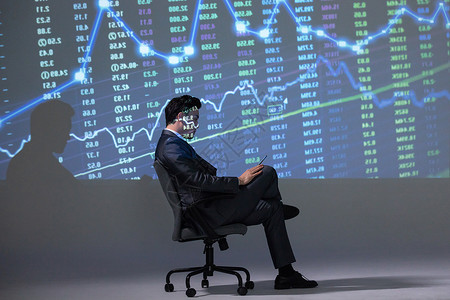 商务男性坐椅子分析股市图背景图片