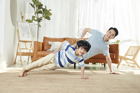 这是在做什么爸爸和孩子在客厅锻炼身体背景