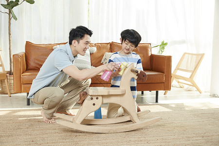 木马玩具年轻爸爸和孩子一起清洁卫生背景