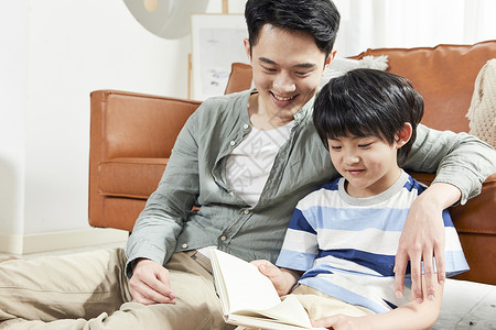年轻爸爸陪儿子读书高清图片