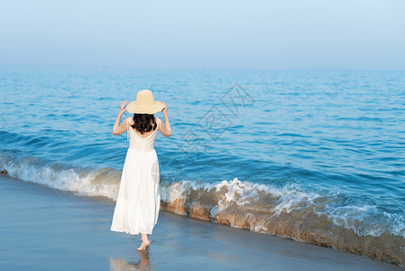 手绘女生连衣裙海边沙滩散步的美女背影背景