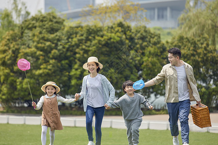 一家人户外牵手奔跑背景图片