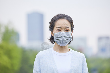 年轻女士户外戴口罩背景图片