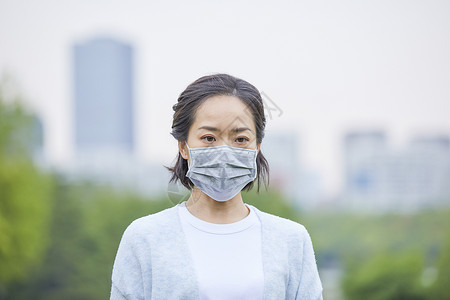 年轻女士户外戴口罩背景图片