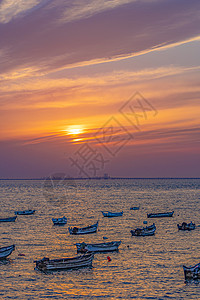 红色夕阳下停泊的渔船图片
