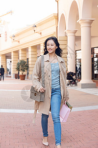户外手提购物袋逛街的青年女性图片