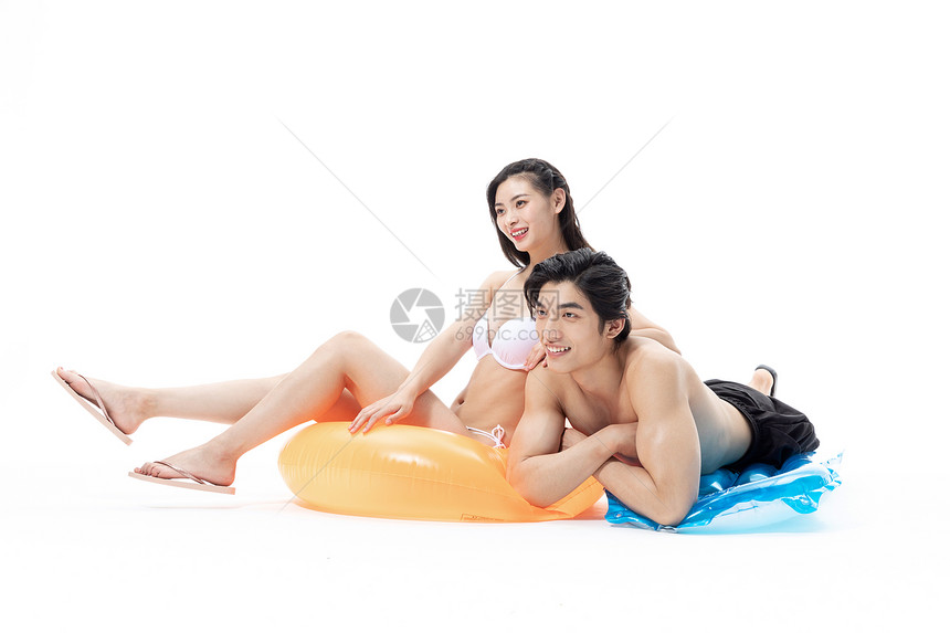 夏日泳装情侣坐在游泳圈上图片