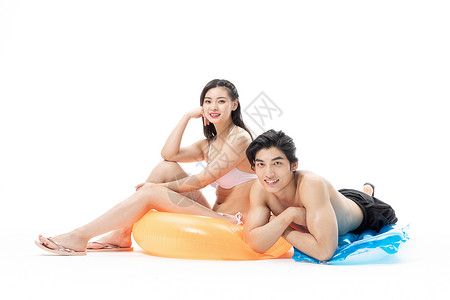充气垫夏日泳装情侣坐在游泳圈上背景