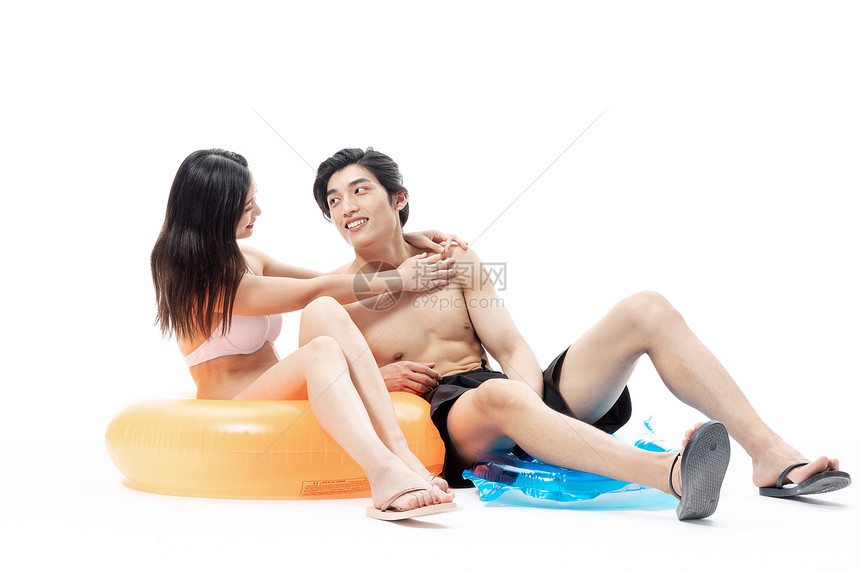 夏日泳装情侣坐在游泳圈上图片
