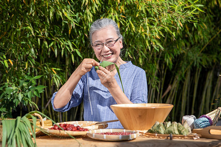 端午节户外奶奶包粽子图片