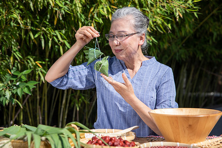 端午节奶奶户外包粽子高清图片