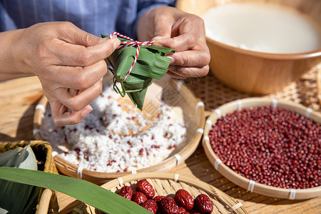 端午节户外奶奶包粽子特写图片