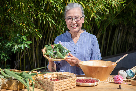 端午节奶奶户外拿着粽子图片