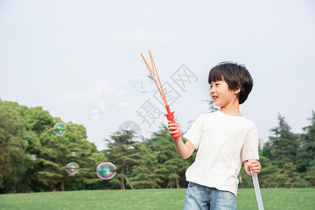 男孩吹泡泡插画在户外吹泡泡的小男孩背景