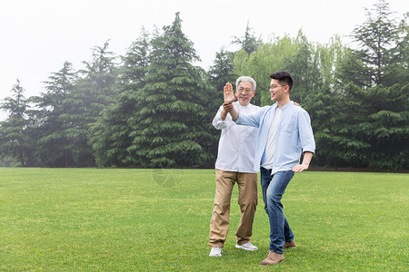 老年父亲教儿子打太极高清图片