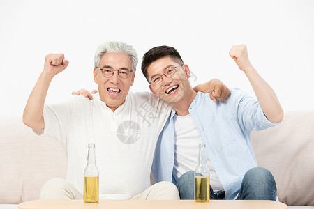 中老年父子坐沙发上喝啤酒庆祝图片