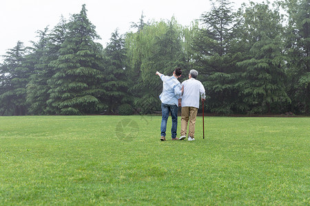 寿星拄拐儿子搀扶父亲拄拐逛公园背景