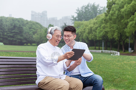 父子听音乐中老年父子公园长椅上听音乐背景