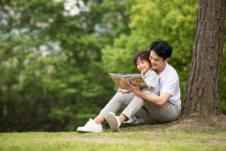 孩子童话父子在公园里看童话故事书背景