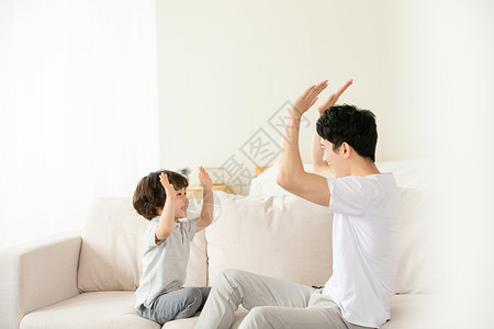 父子沙发上亲密击掌拍手游戏背景