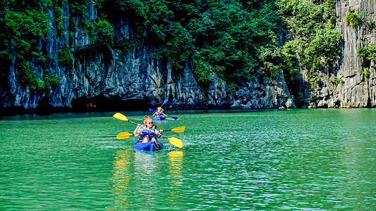 夏季旅游的孩子越南下龙湾玩皮划艇背景