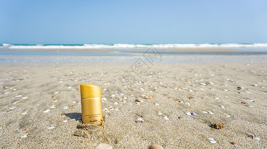 金色产品在沙滩上拍摄防晒霜背景