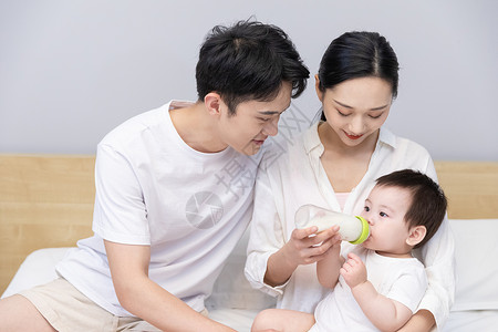 一家三口爸爸妈妈喂婴儿喝奶高清图片