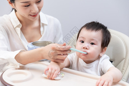 宝宝牙刷妈妈喂小宝宝吃辅食背景