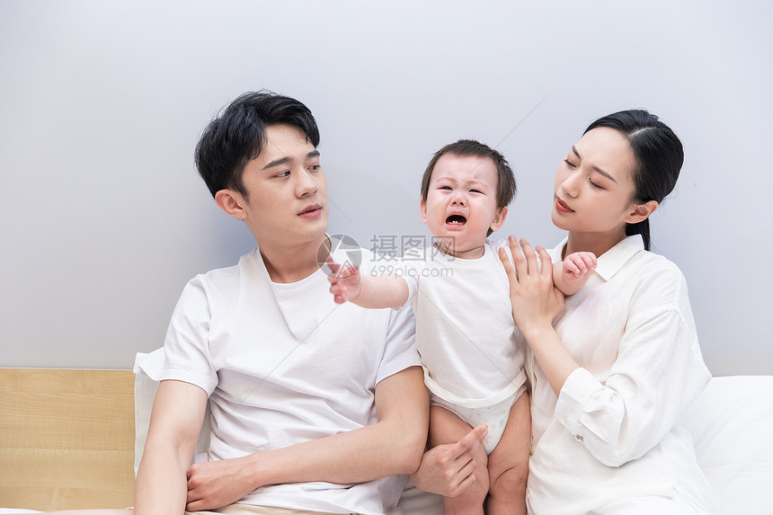 一家三口哄哭泣的婴儿图片