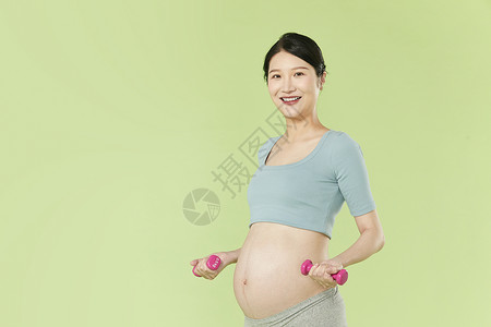 孕妇锻炼健身孕妇用哑铃健身背景