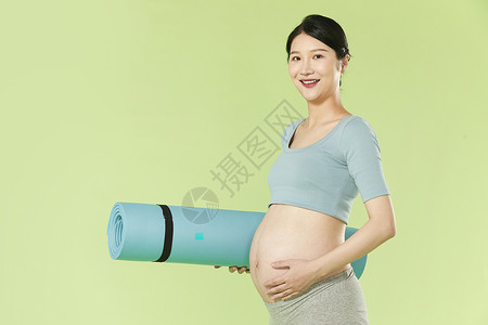 腰垫孕妇拿着瑜伽垫背景
