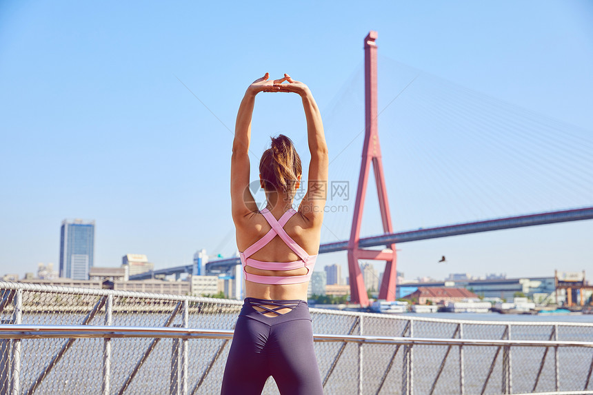运动女性伸展手臂热身背影图片