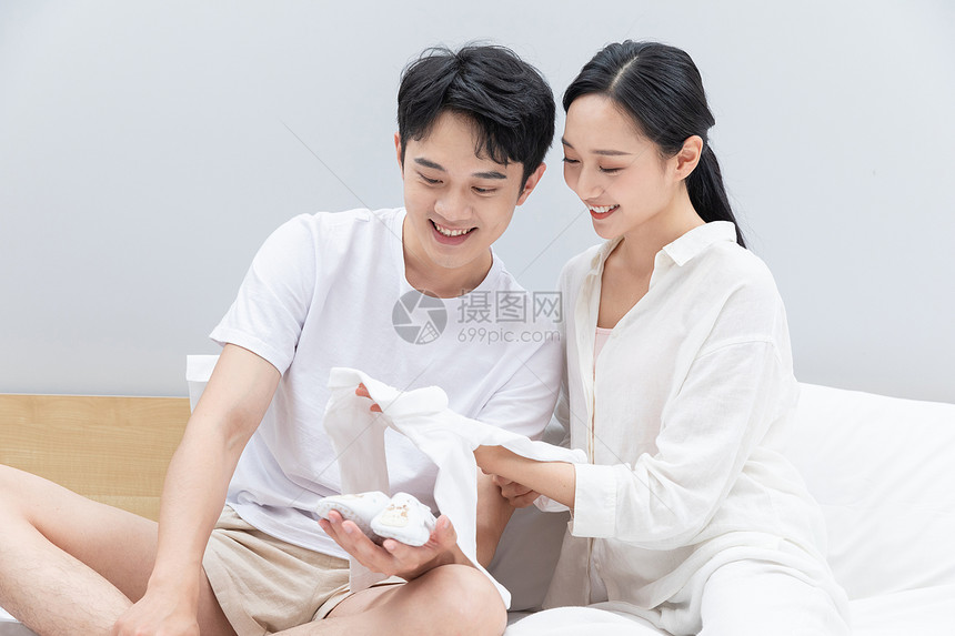 准爸爸准妈妈拿着婴儿衣服图片